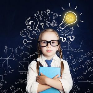 Cheerful child at the blackboard with lightbulb and mathematics formulas. Problem and solution. Ideas concept
