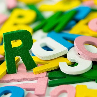 Close up of wooden alphabets forming background. Representing phonics and spelling
