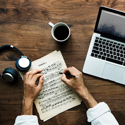 Music, earphones, laptop and coffee. Symbolising online music resources like Charanga.