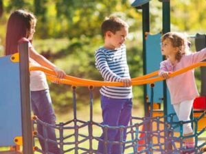 Three children playing together in the playground. Representing Safeguarding and Child Protection Inset Training