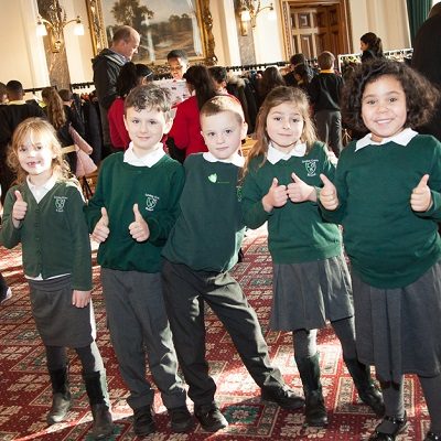 Picture of some children smiling with their thumbs up at a health for life event