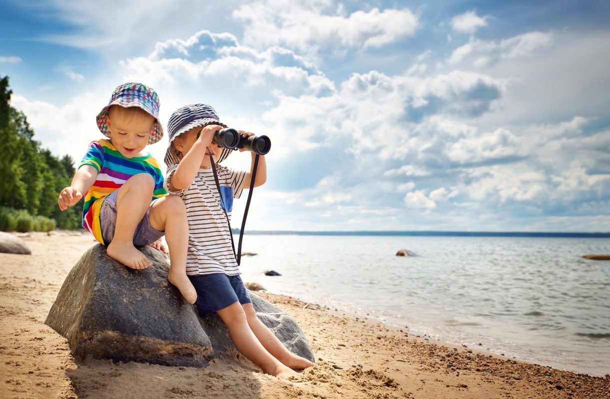 Babygirl and babyboy sitting on the beach in summer hats - 11-Activities-To-Do-With-Children-In-Birmingham-This-Easter