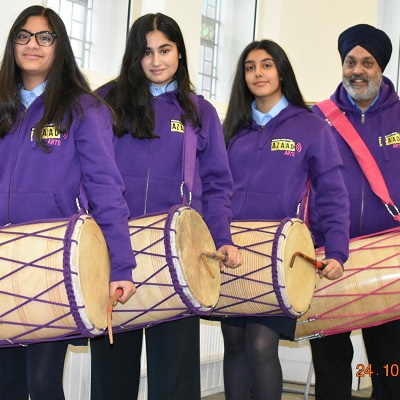 3 girls and their dhol teacher getting ready to play dhol drums