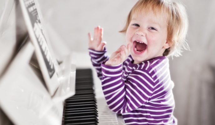 girl smiling and playing piano