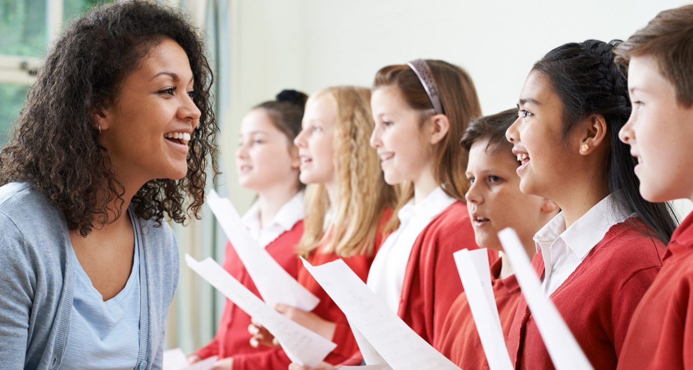 children singing in class with their teacher