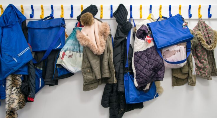 Children's coats and bags hung up on pegs