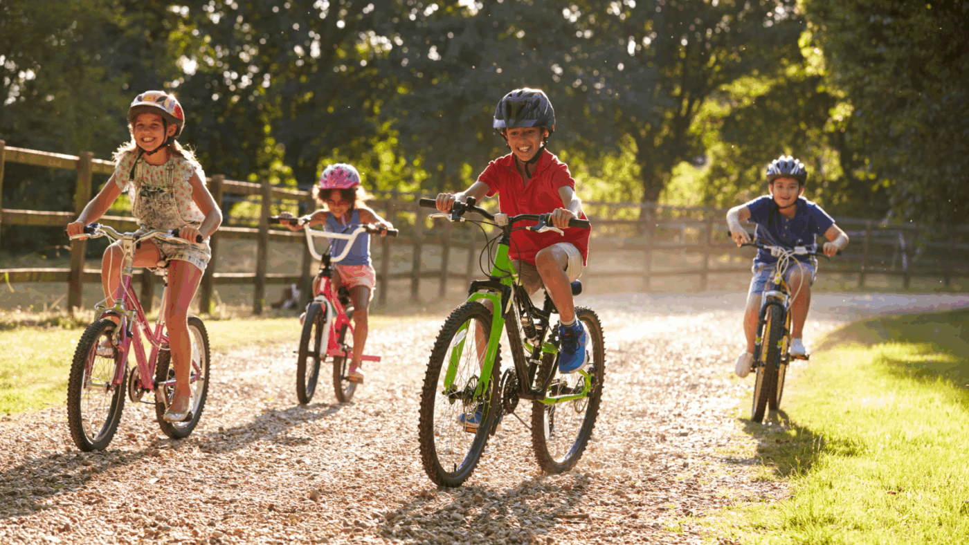 Four children cycling together in the summer