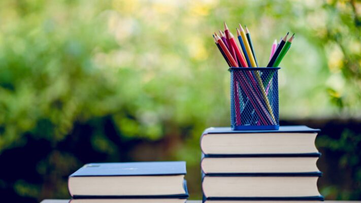 School books and pencils in a summer setting.